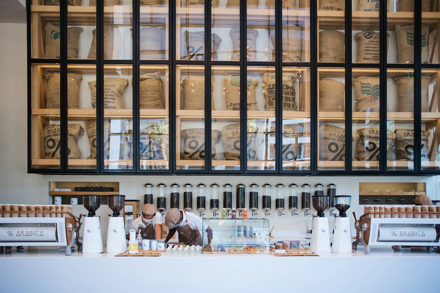 A café owner working behind the counter, preparing an order by the coffee machine